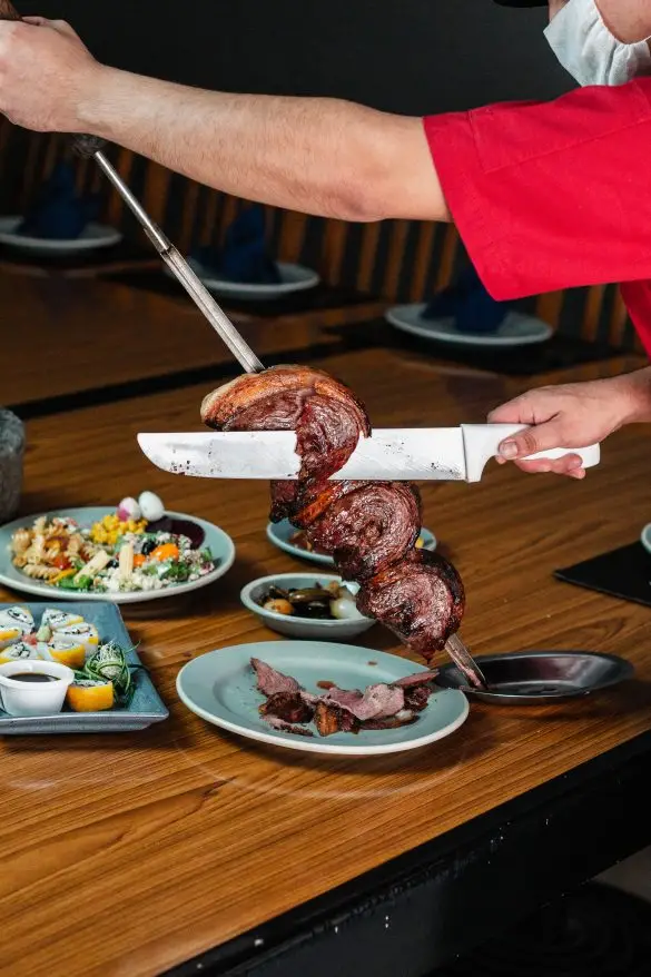 Picanha being carved in a Brazilian Churrascaria